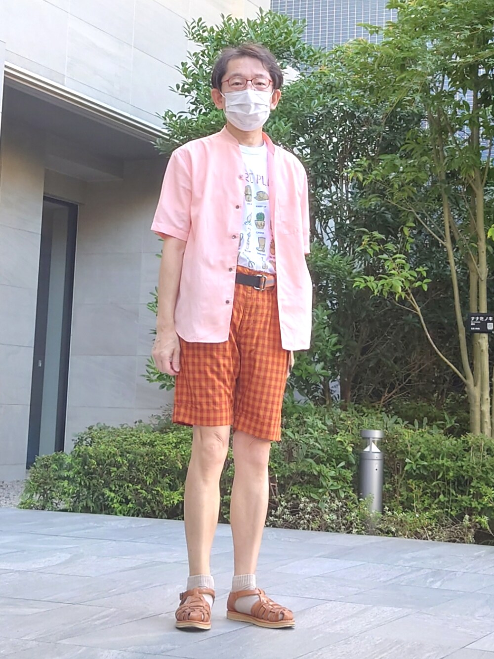 ベージュ系のサンダル、オレンジ系のセットアップ、ホワイト系のTシャツ/カットソーを着用したメンズの夏コーディネートの1枚目の写真