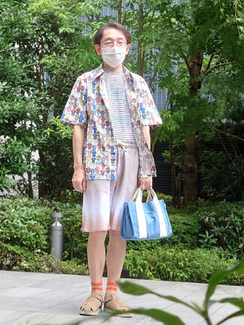 ブルー系のトートバッグ、ベージュ系のサンダル、イエロー系のその他パンツを着用したメンズの夏コーディネートの1枚目の写真