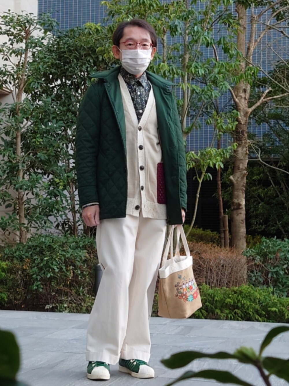 ベージュ系のトートバッグ、グリーン系のスニーカー、グリーン系のダウンジャケット/コートを着用したメンズの冬コーディネートの1枚目の写真