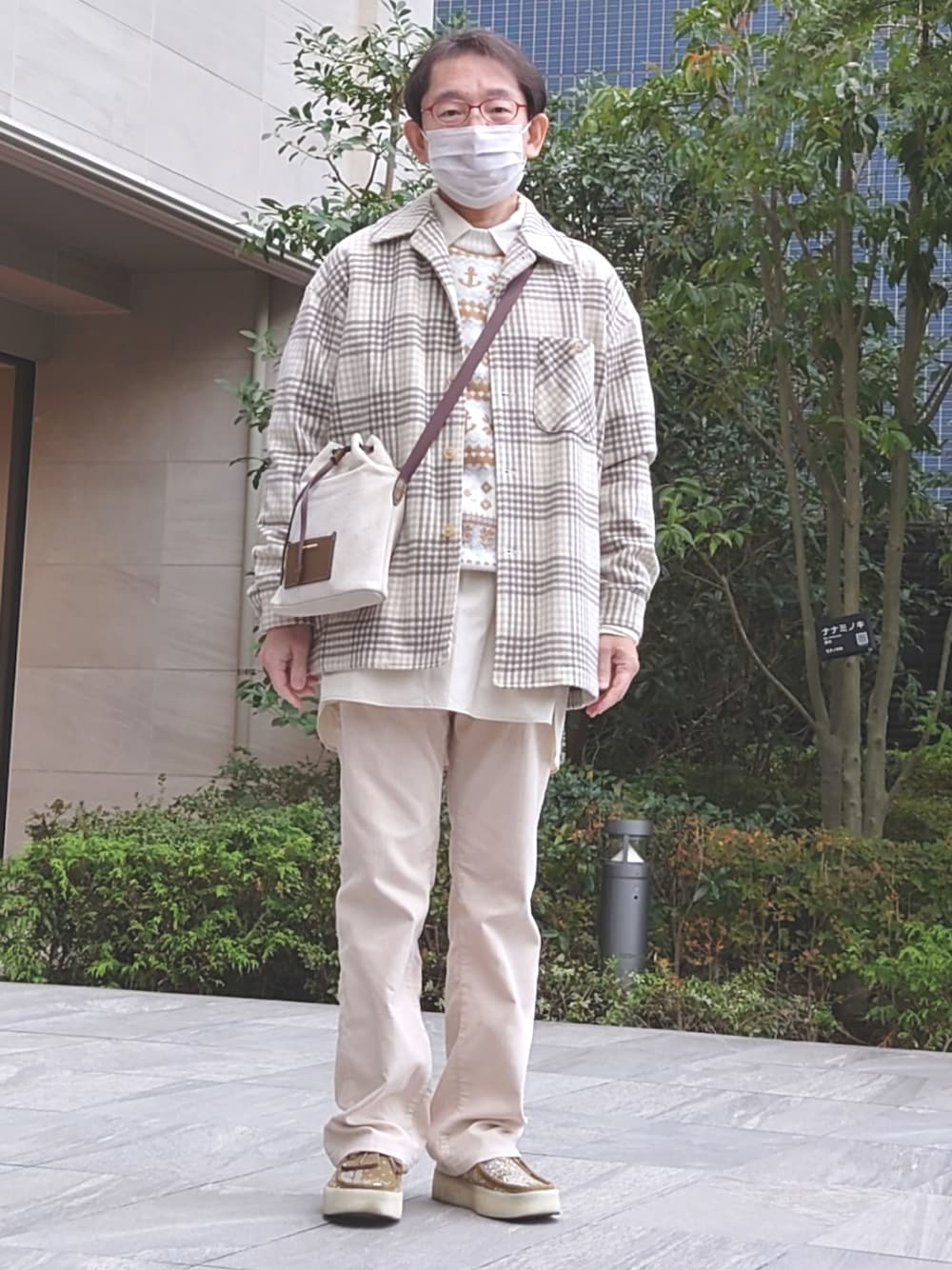 ベージュ系のパンツ、ベージュ系のモカシン/デッキシューズ、ブラウン系のショルダーバッグを着用したメンズの秋コーディネートの1枚目の写真