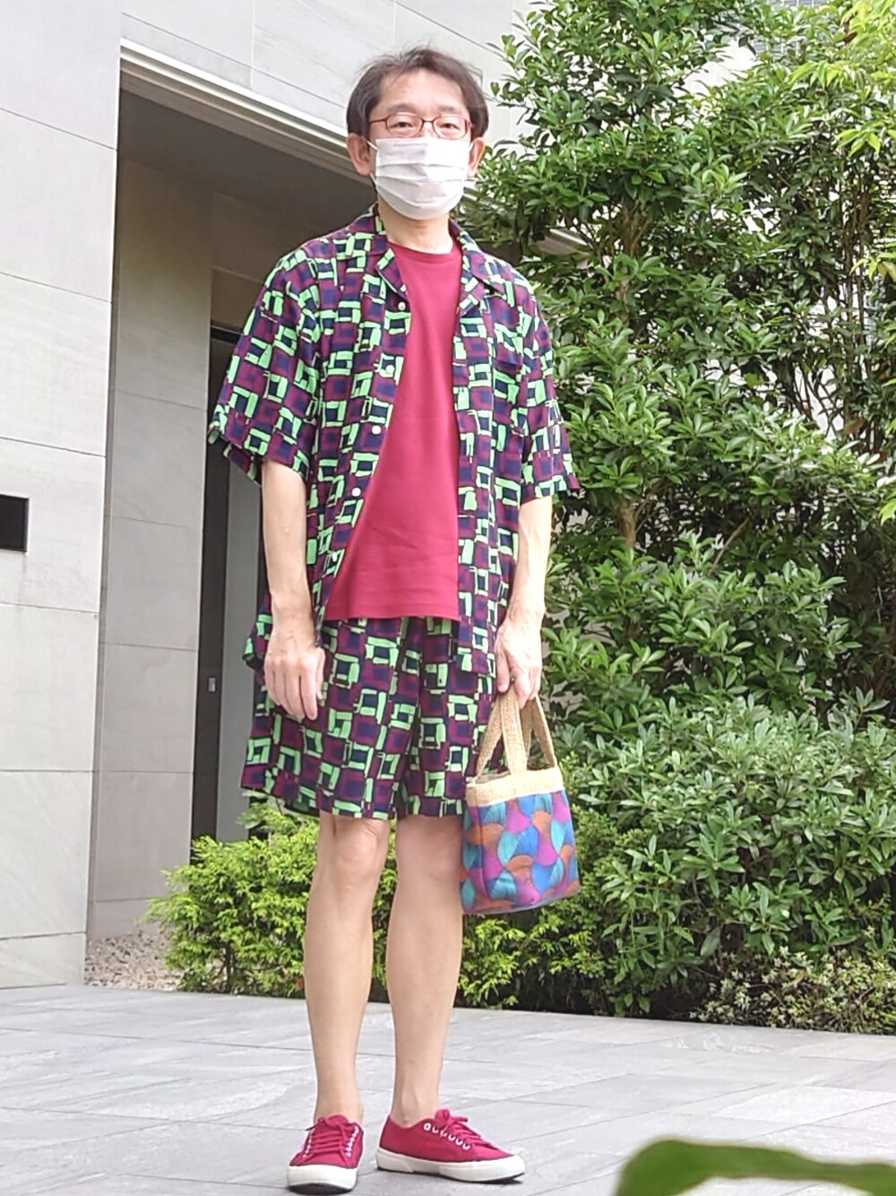 レッド系のスニーカー、ブルー系のバッグ、グリーン系のその他パンツを着用したメンズの夏コーディネートの1枚目の写真
