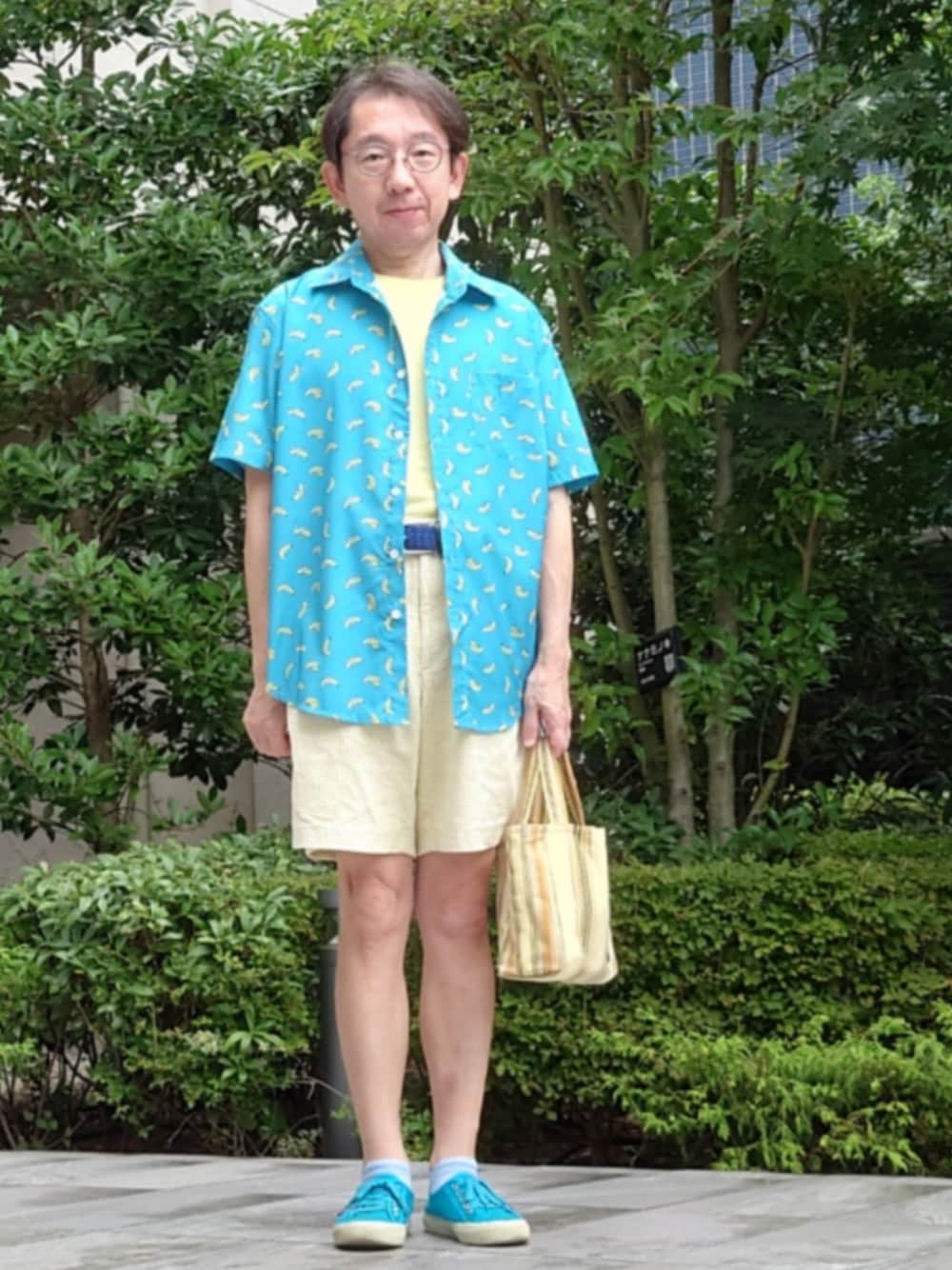 イエロー系のバッグ、ブルー系のシューズ、イエロー系のパンツを着用したメンズの夏コーディネートの1枚目の写真