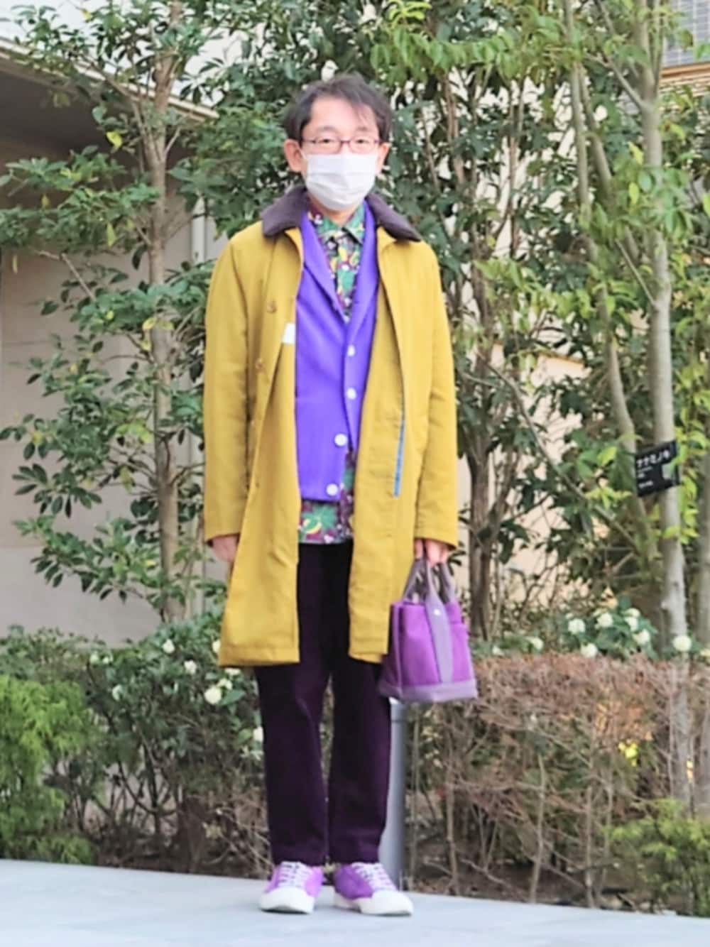 イエロー系のステンカラーコート、パープル系のバッグ、パープル系のその他パンツを着用したメンズの春コーディネートの1枚目の写真