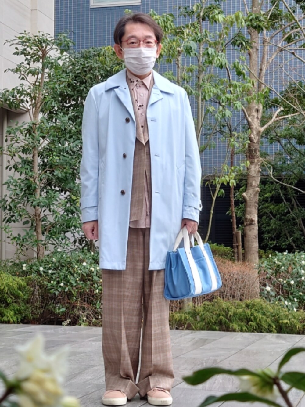 ブルー系のトートバッグ、ブラウン系のパンツ、ピンク系のスニーカーを着用したメンズの春コーディネートの1枚目の写真