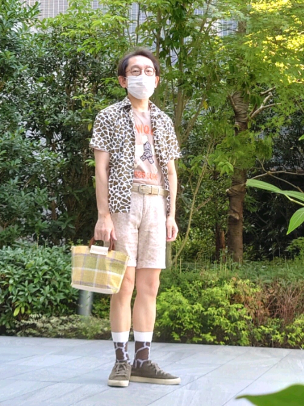 グリーン系のトートバッグ、グリーン系のシャツ/ブラウス、ベージュ系のTシャツ/カットソーを着用したメンズの夏コーディネートの1枚目の写真