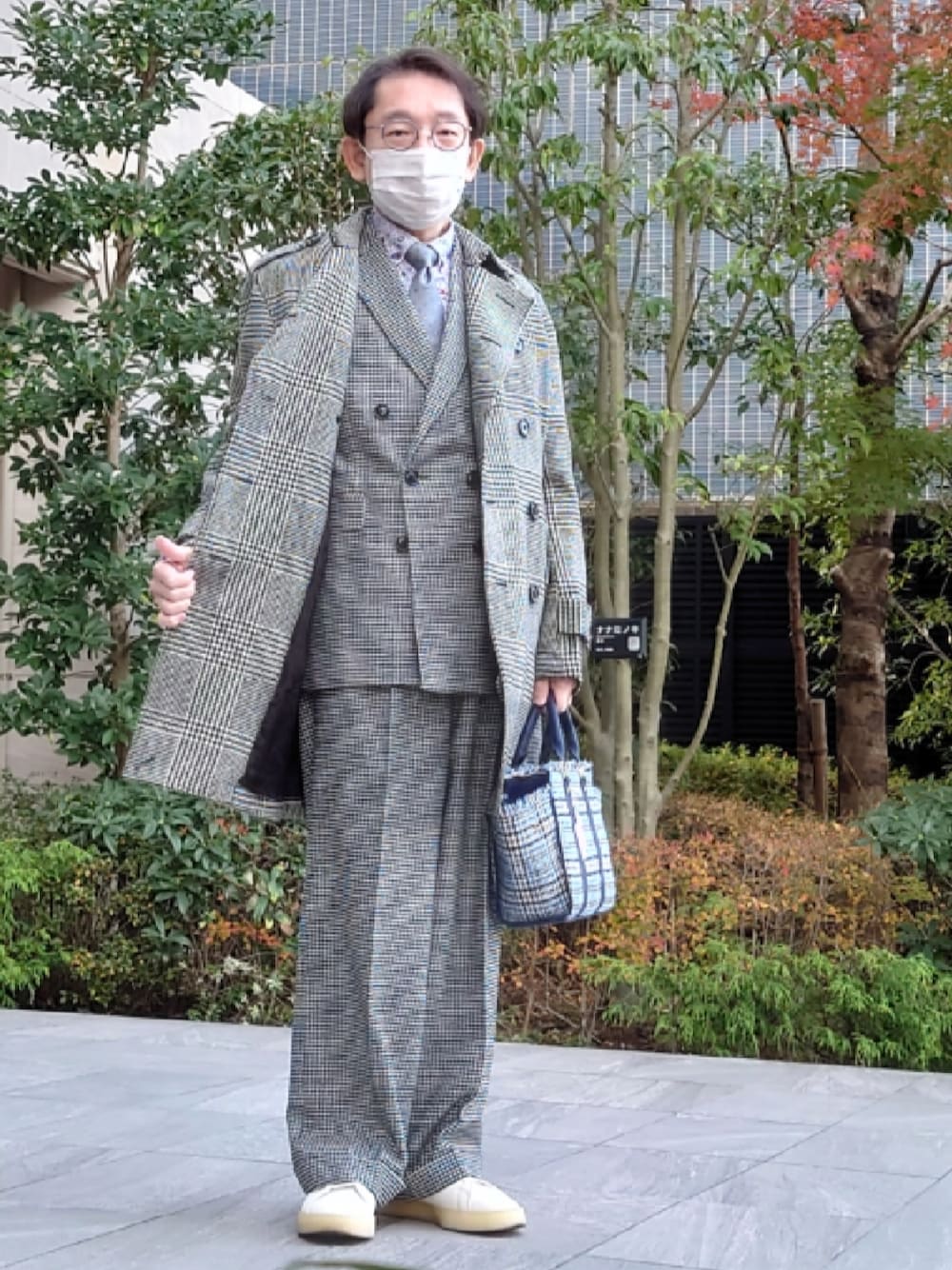 ブルー系のハンドバッグ、グレー系のその他パンツ、ホワイト系のスニーカーを着用したメンズの冬コーディネートの1枚目の写真