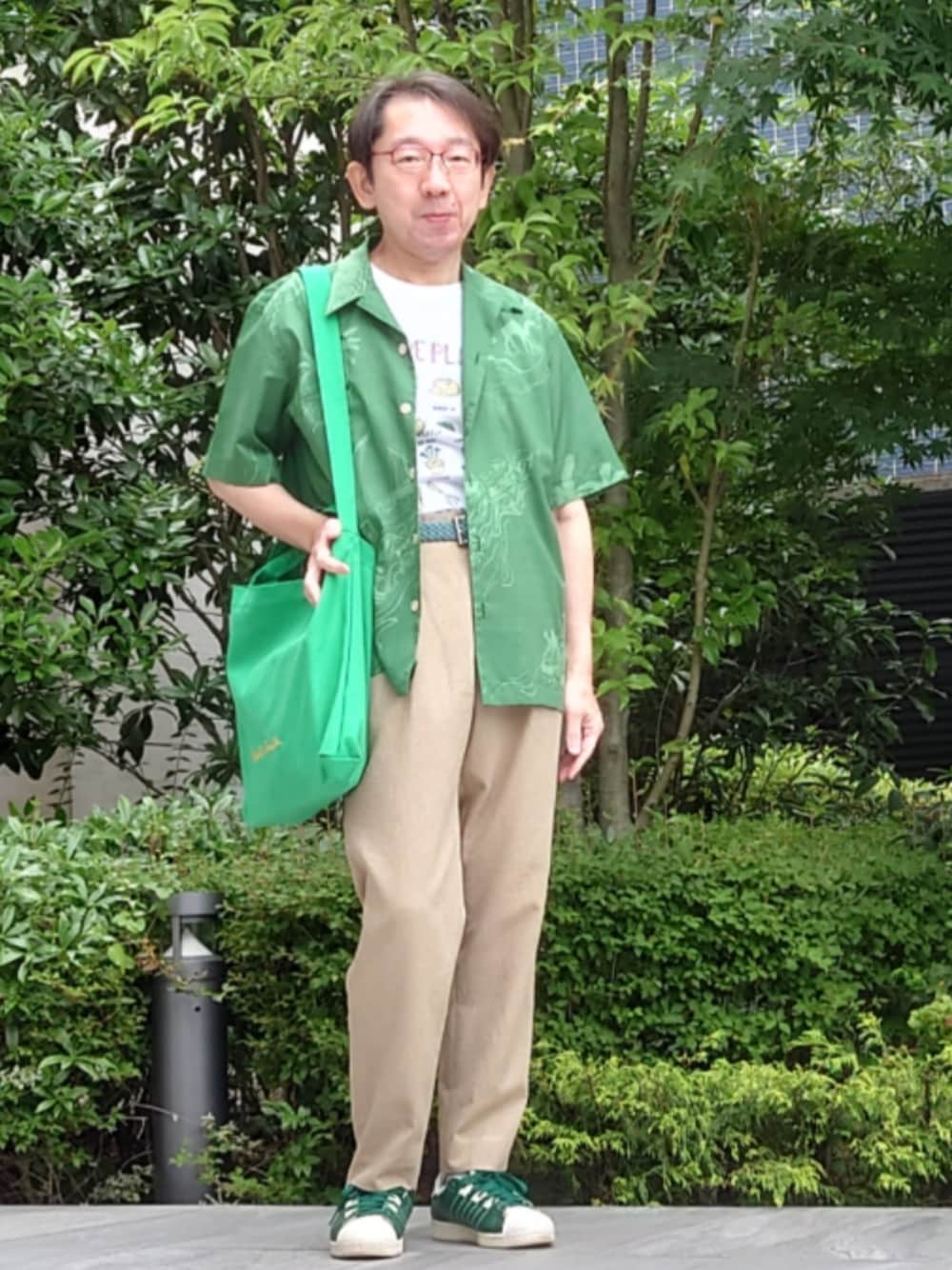 グリーン系のシャツ/ブラウス、ホワイト系のTシャツ/カットソー、ベージュ系のスラックスを着用したメンズの夏コーディネートの1枚目の写真