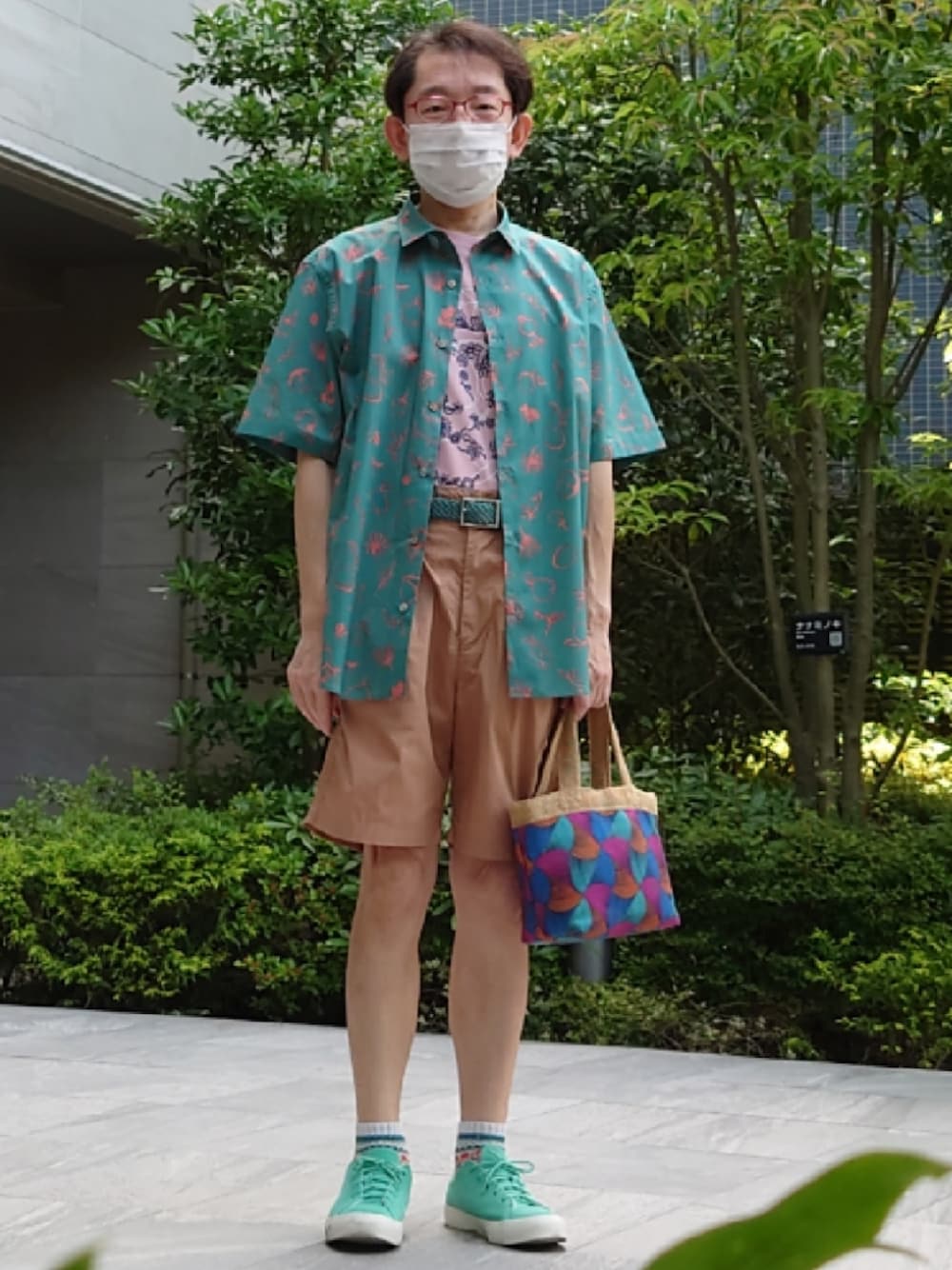 ブルー系のバッグ、グリーン系のスニーカー、ベージュ系のその他パンツを着用したメンズの春コーディネートの1枚目の写真