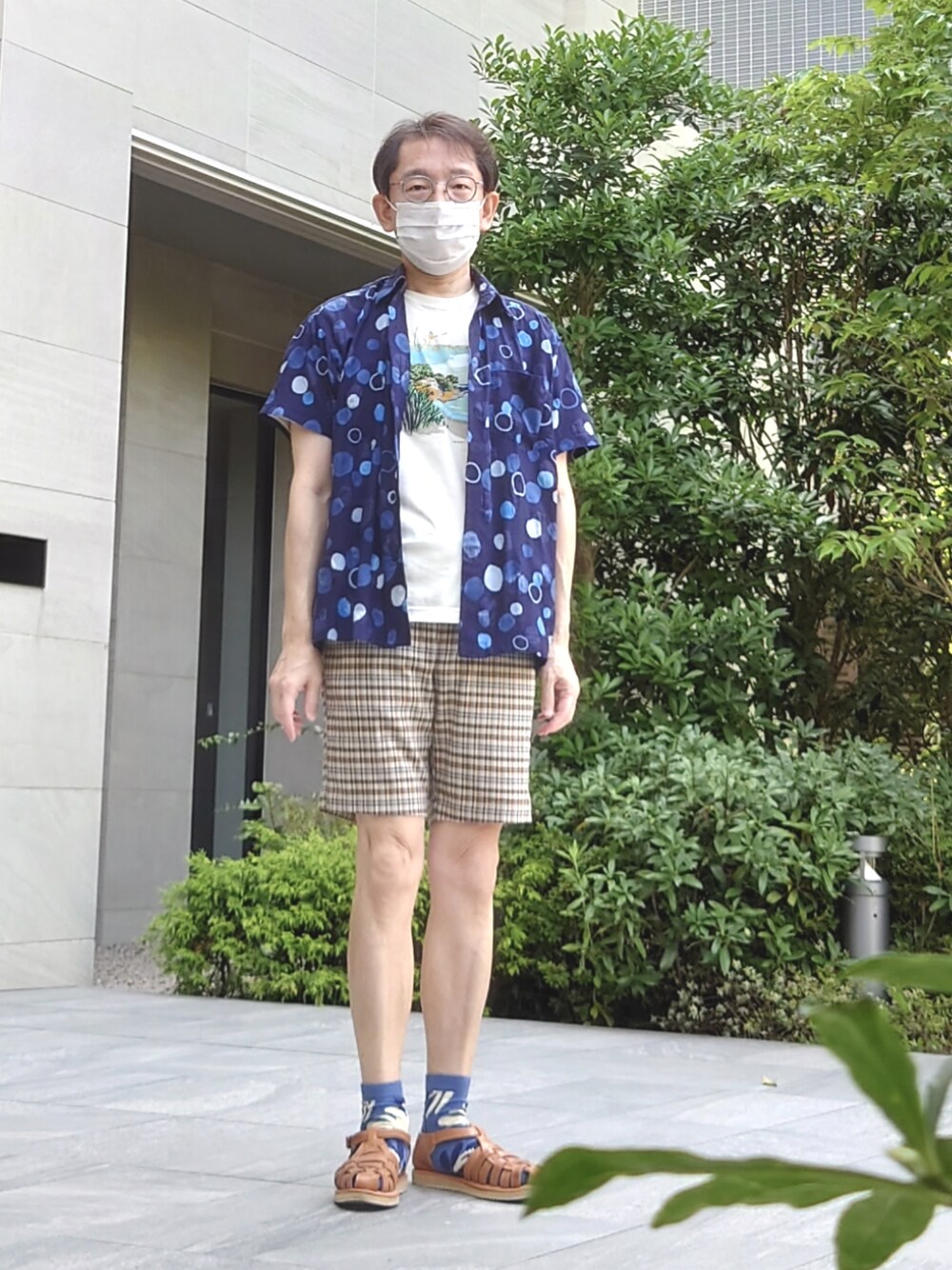 ベージュ系のサンダル、ブルー系のシャツ/ブラウス、ベージュ系のTシャツ/カットソーを着用したメンズの夏コーディネートの1枚目の写真