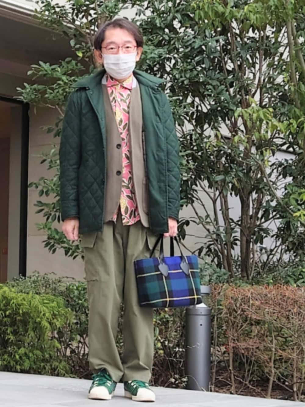 グリーン系のダウンジャケット/コート、ブルー系のショルダーバッグ、グリーン系のスニーカーを着用したメンズの冬コーディネートの1枚目の写真