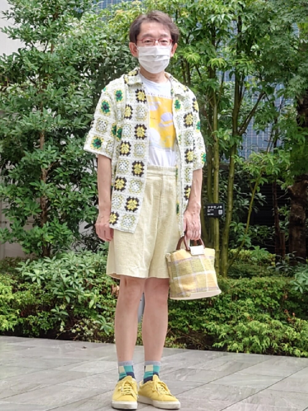 グリーン系のトートバッグ、イエロー系のパンツ、ホワイト系のTシャツ/カットソーを着用したメンズの夏コーディネートの1枚目の写真