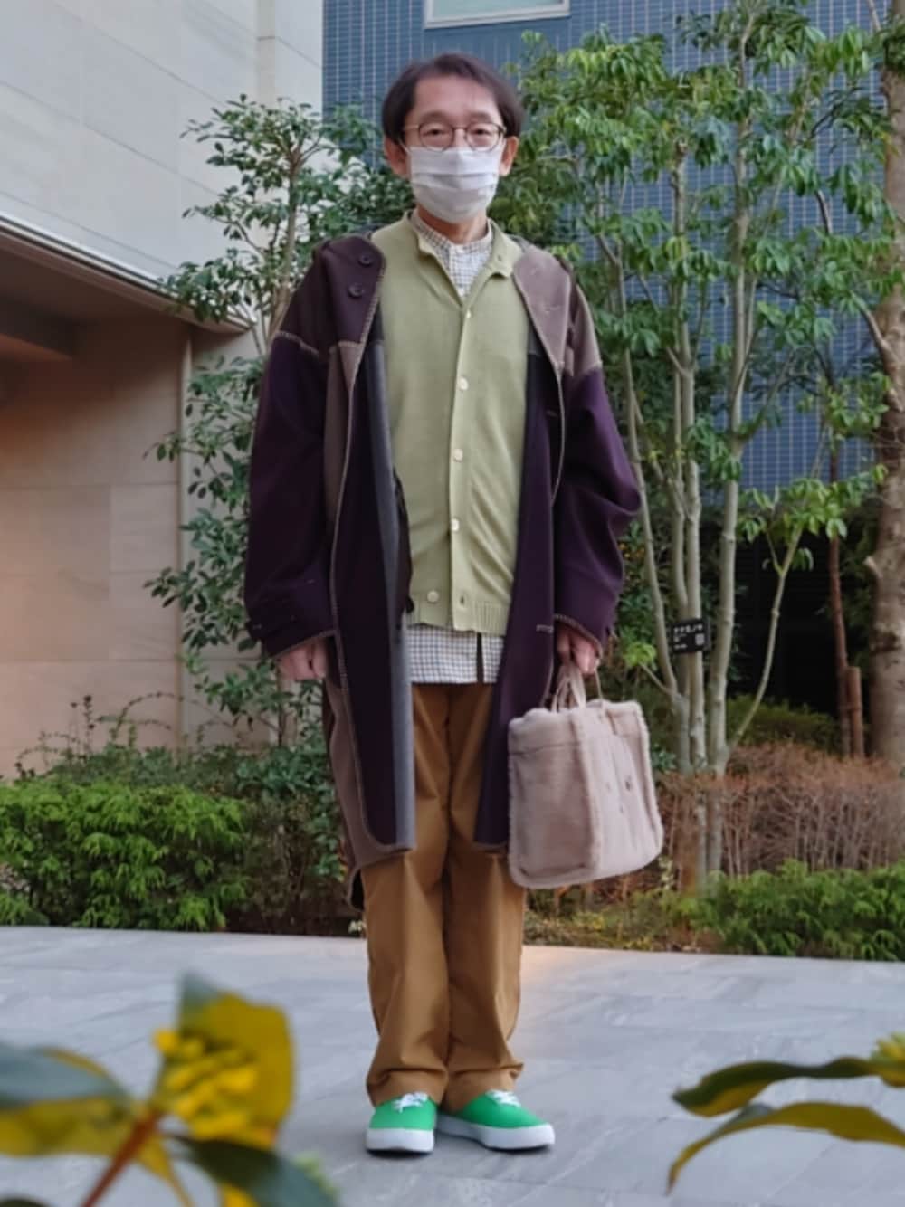 ベージュ系のハンドバッグ、ベージュ系のパンツ、グリーン系のシューズを着用したメンズの冬コーディネートの1枚目の写真