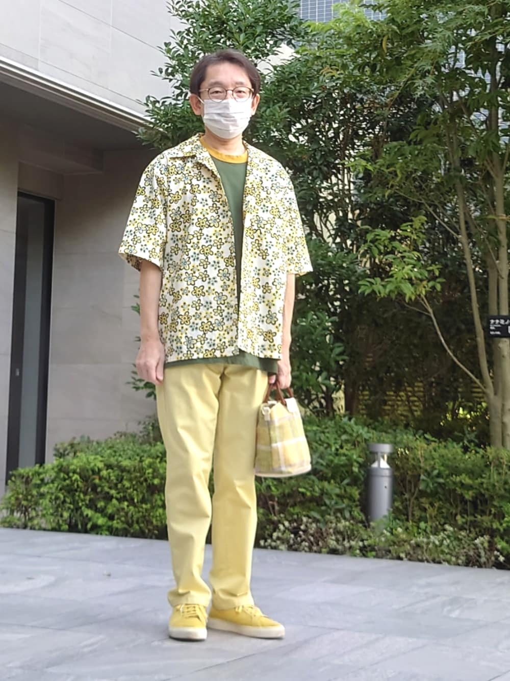 イエロー系のパンツ、グリーン系のトートバッグ、イエロー系のスニーカーを着用したメンズの秋コーディネートの1枚目の写真