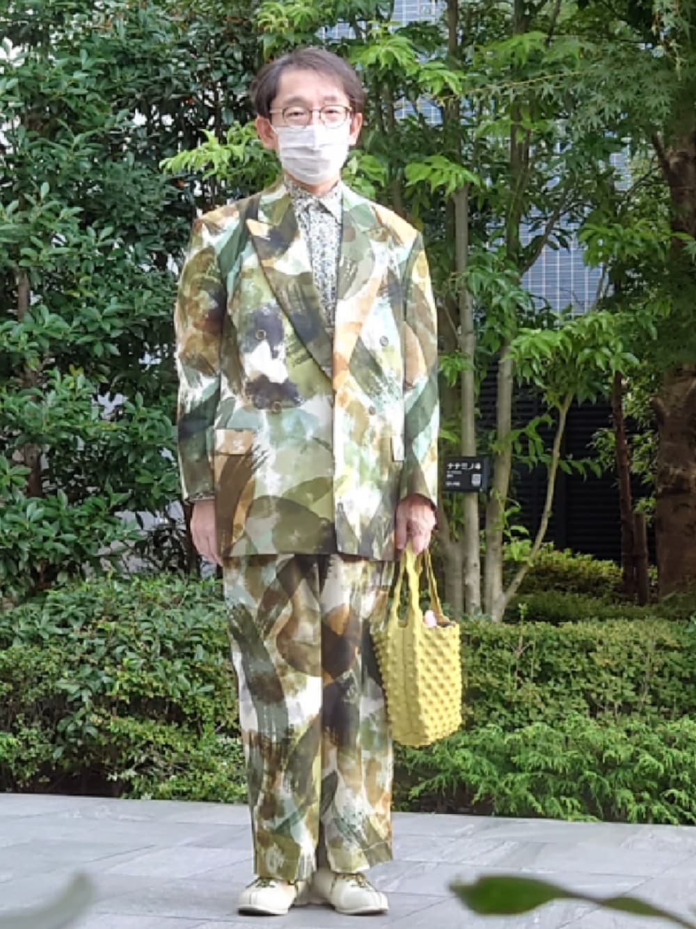 イエロー系のハンドバッグ、ホワイト系のドレスシューズ、グリーン系のジャケット/アウターを着用したメンズの秋コーディネートの1枚目の写真