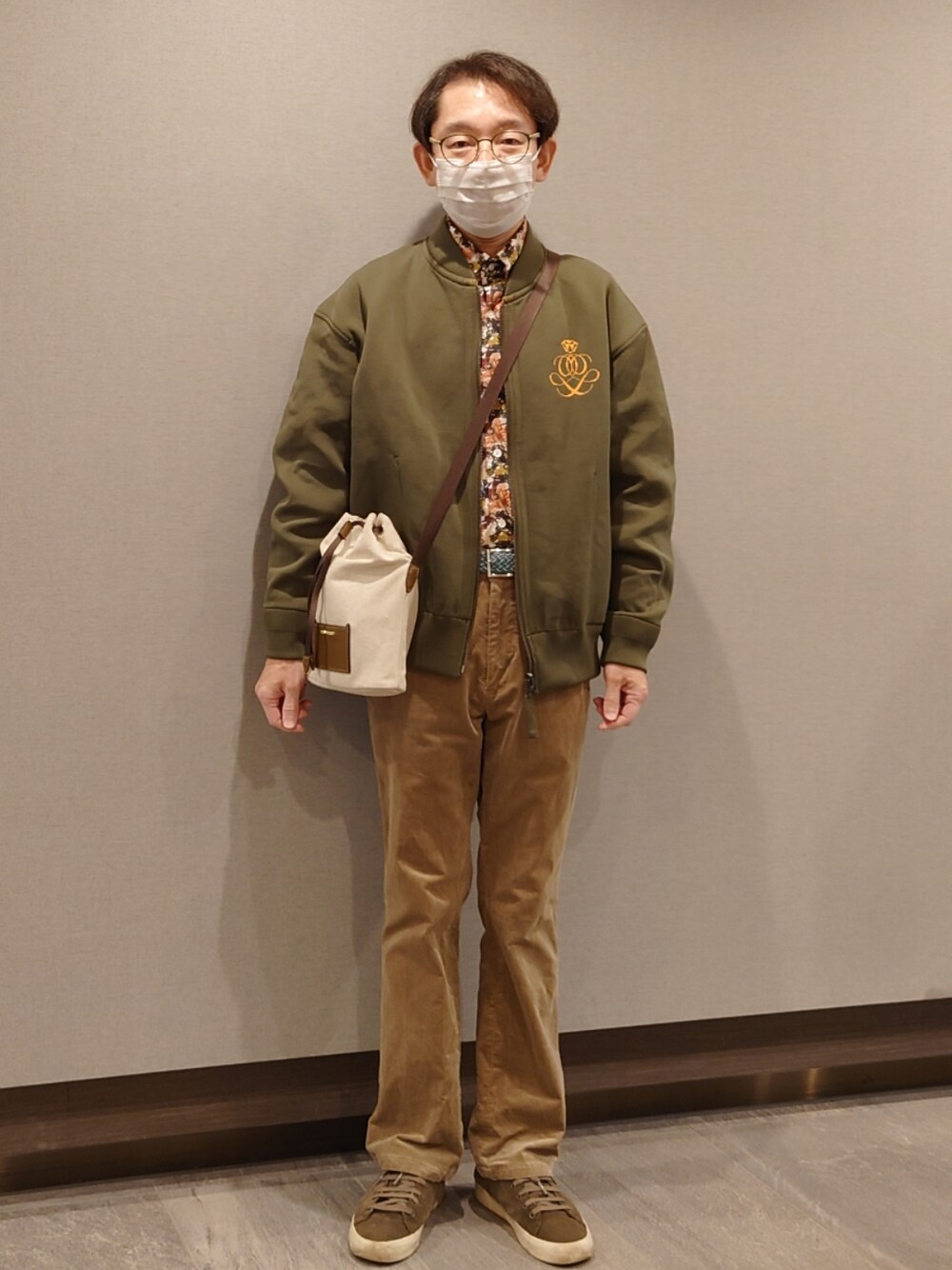 ベージュ系のその他パンツ、グリーン系のシューズ、ブラウン系のショルダーバッグを着用したメンズの春コーディネートの1枚目の写真