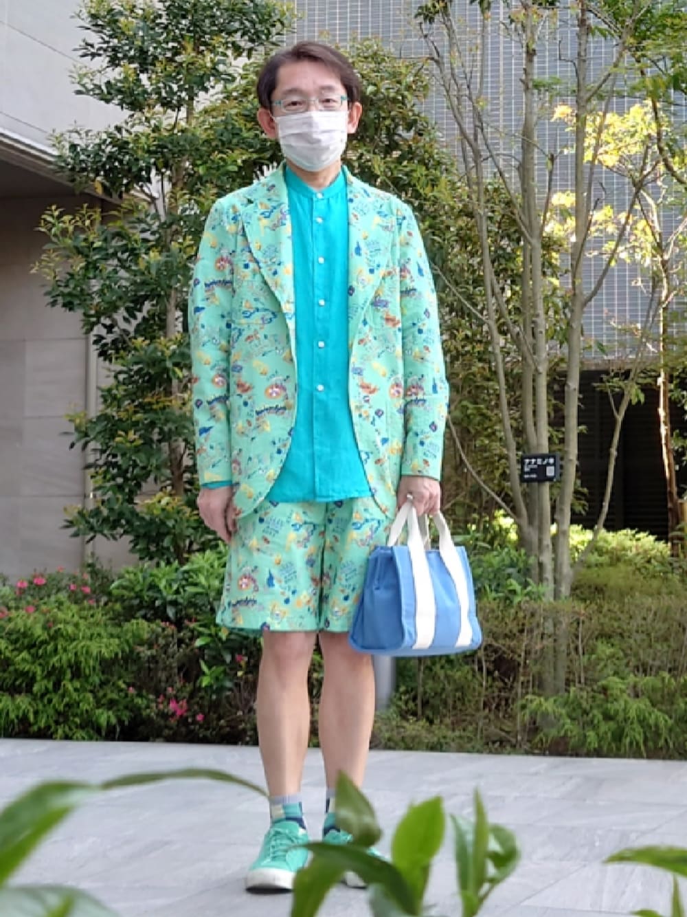 ブルー系のトートバッグ、グリーン系のその他パンツ、グリーン系のスニーカーを着用したメンズの春コーディネートの1枚目の写真