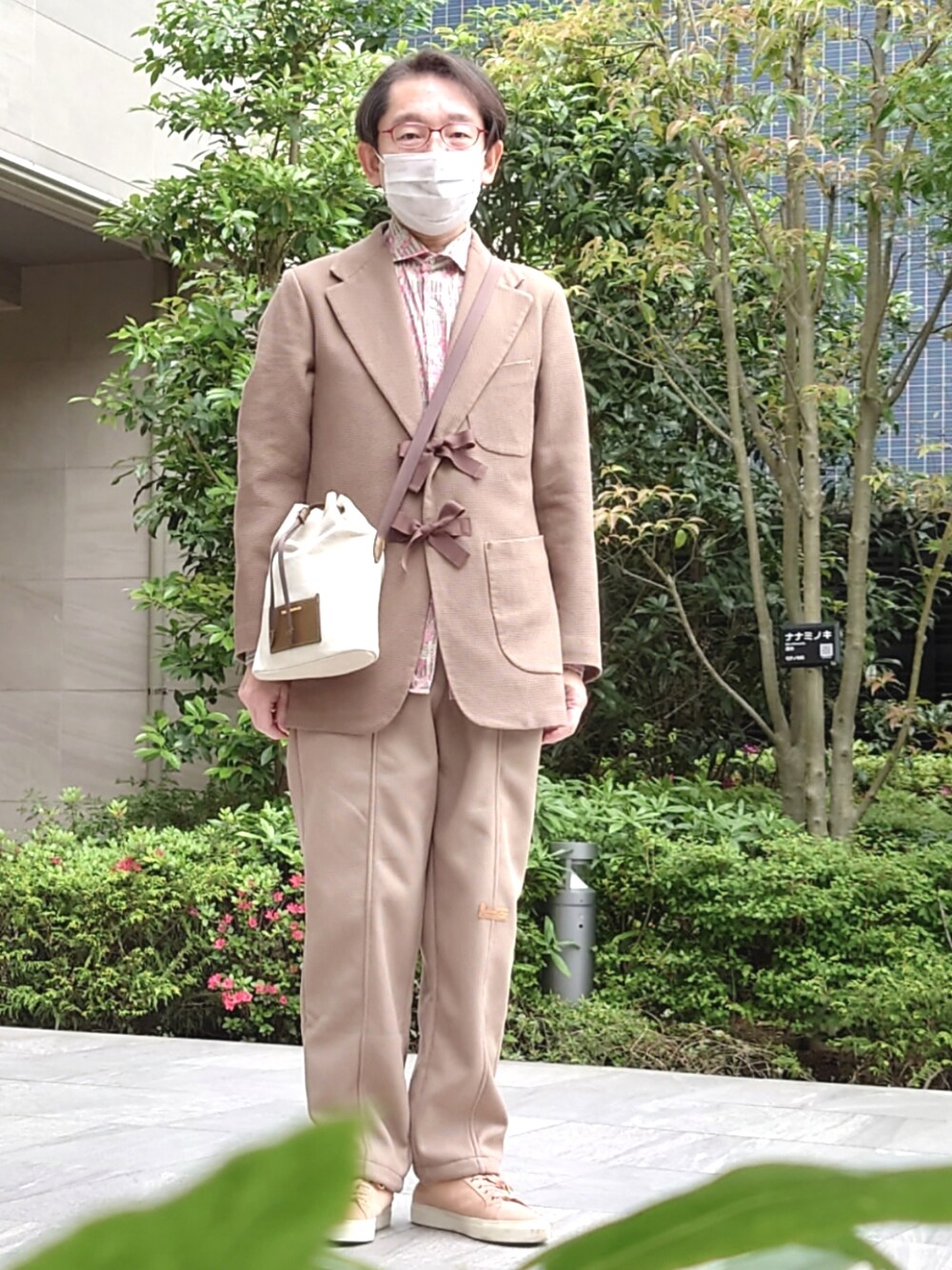 ベージュ系のその他パンツ、ピンク系のスニーカー、ブラウン系のショルダーバッグを着用したメンズの春コーディネートの1枚目の写真