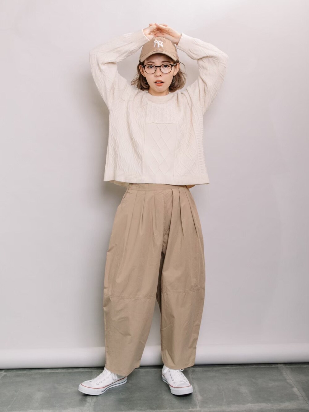 ホワイト系のニット/セーター、ベージュ系のその他パンツ、ホワイト系のスニーカーを着用したレディースの春コーディネートの1枚目の写真