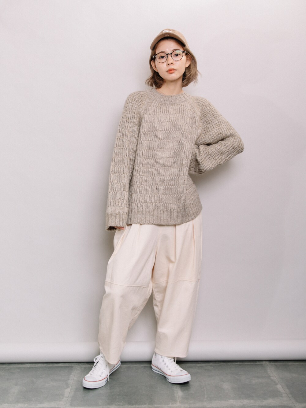 ベージュ系のニット/セーター、ホワイト系のその他パンツ、ホワイト系のスニーカーを着用したレディースの秋コーディネートの1枚目の写真