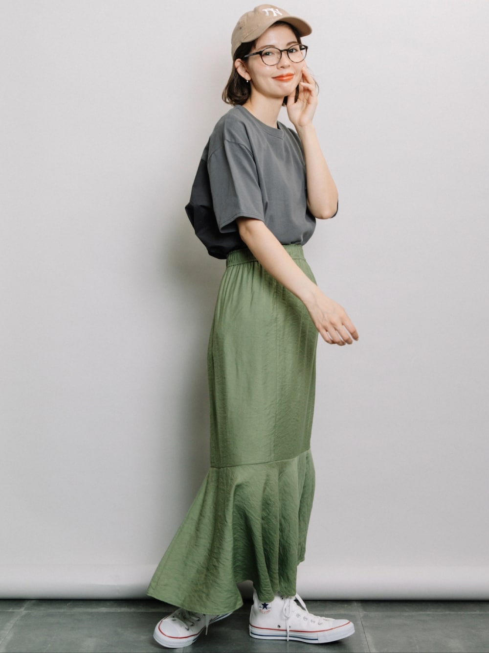 グレー系のTシャツ/カットソー、グリーン系のスカート、ホワイト系のスニーカーを着用したレディースの春コーディネートの1枚目の写真