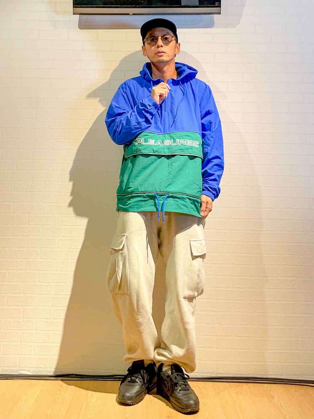 ブルー系のナイロンジャケット、グレー系のカーゴパンツ、ブラック系のスニーカーを着用したメンズの秋コーディネートの1枚目の写真