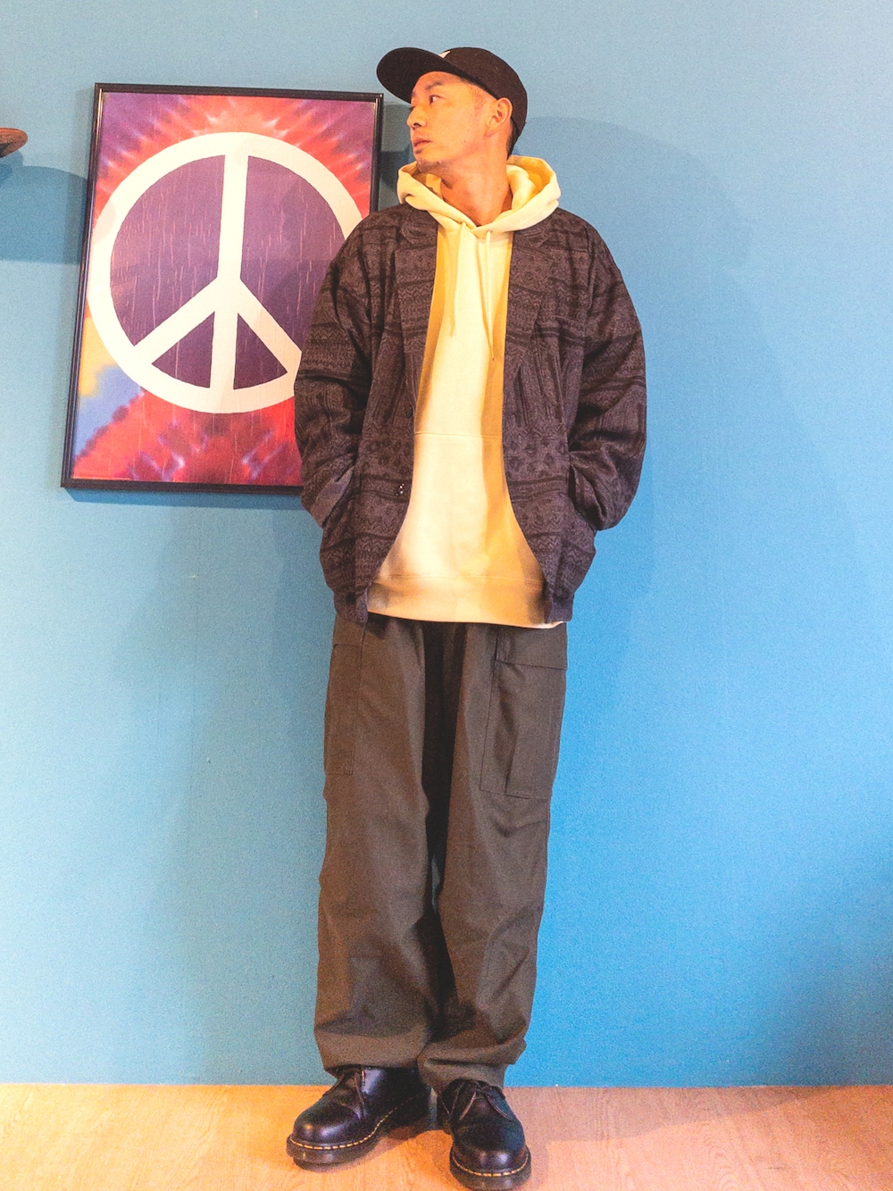 グリーン系のカーゴパンツ、ブラック系のブーツ、グレー系のテーラードジャケットを着用したメンズの春コーディネートの1枚目の写真