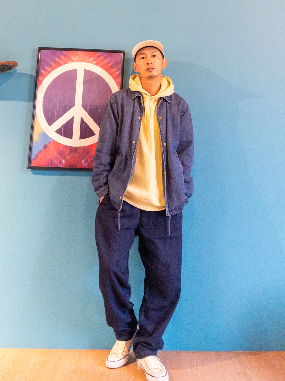 ブルー系のデニムジャケット、イエロー系のパーカー、ブルー系のその他パンツを着用したメンズの春コーディネートの1枚目の写真