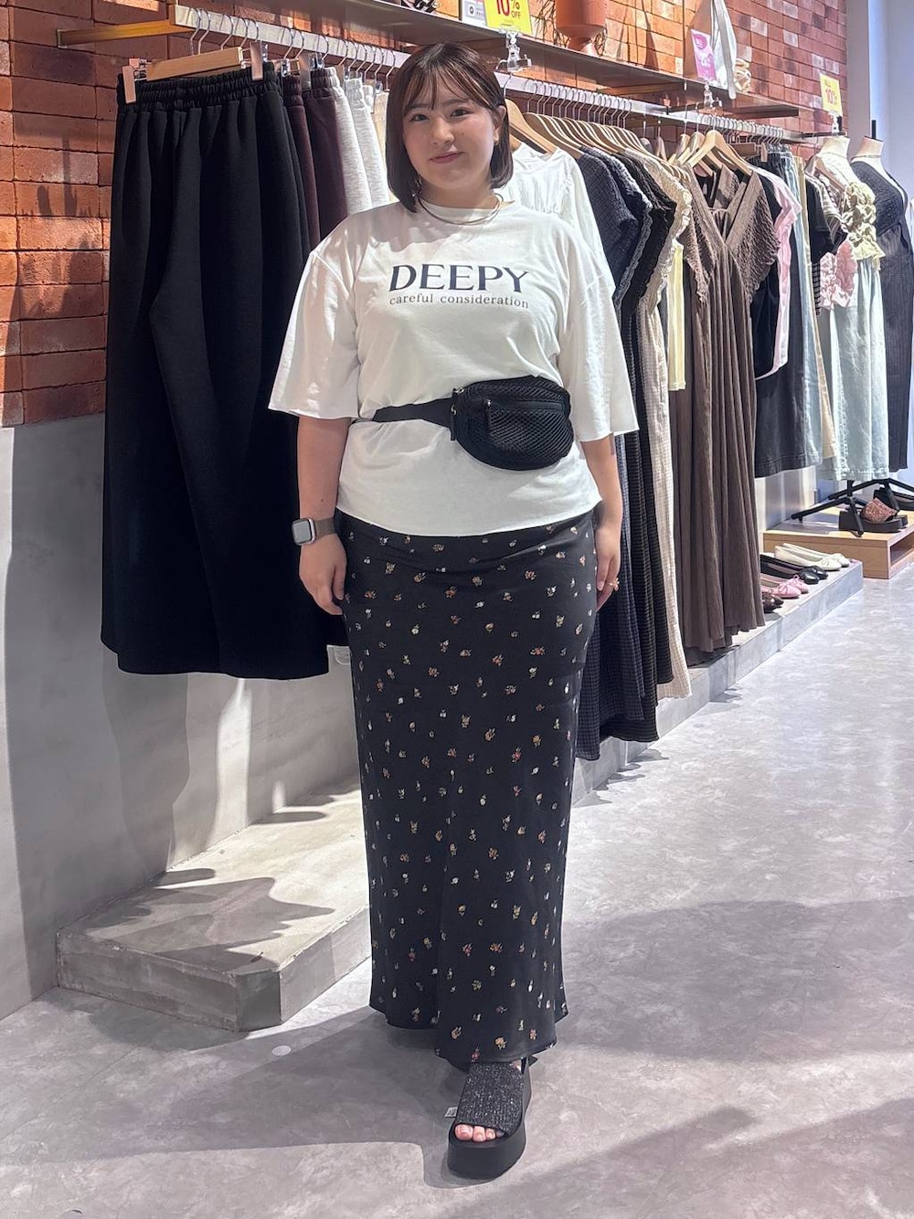 ホワイト系のTシャツ/カットソー、ブラック系のスカート、ブラック系のボディバッグ/ウエストポーチを着用したレディースの夏コーディネートの1枚目の写真