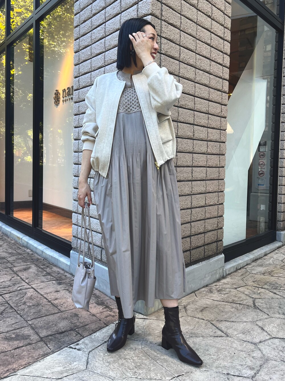 ベージュ系のブルゾン、ベージュ系のワンピース、グレー系のトートバッグを着用したレディースの秋コーディネートの1枚目の写真