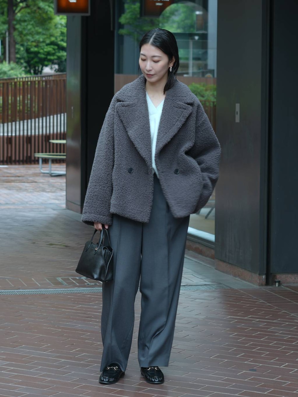 グレー系のその他パンツ、ブラック系のローファー、ブルー系のニット/セーターを着用したレディースの秋コーディネートの1枚目の写真