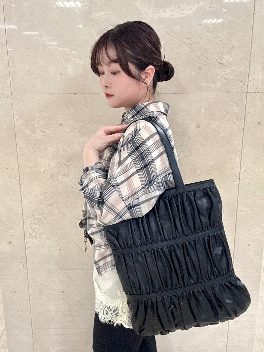 ブラック系のトートバッグを着用したレディースの夏コーディネートの1枚目の写真