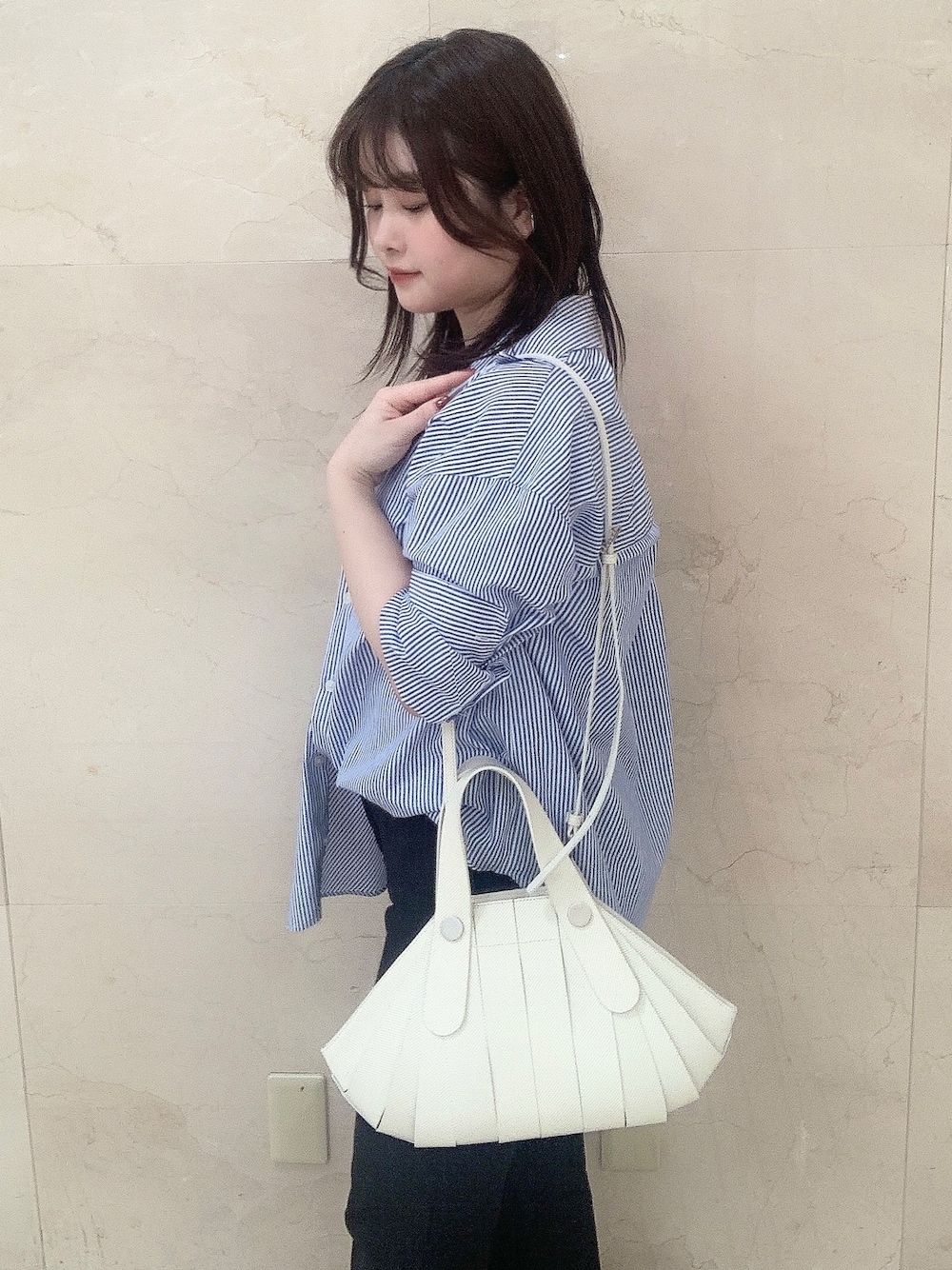 ホワイト系のハンドバッグを着用したレディースの夏コーディネートの1枚目の写真
