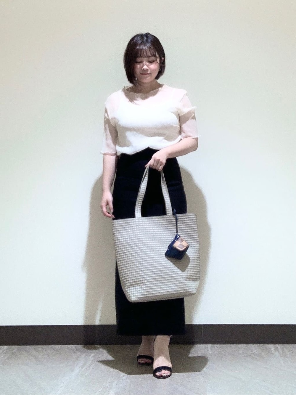 ベージュ系のトートバッグ、ベージュ系のポーチを着用したレディースの夏コーディネートの1枚目の写真