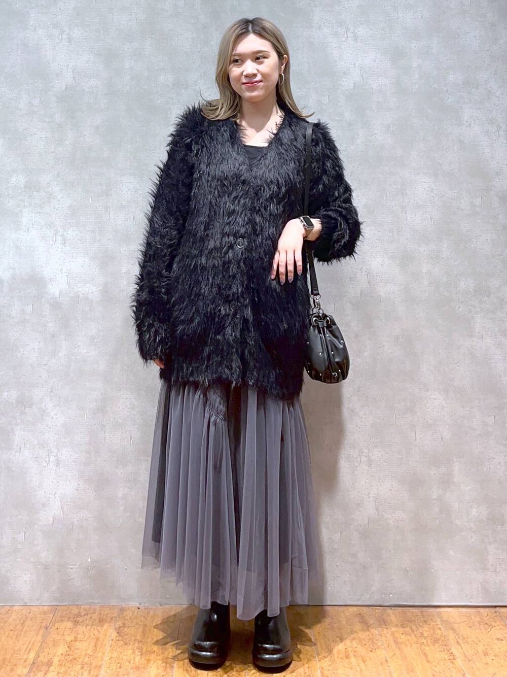 ブラック系のカーディガン/ボレロ、ブラック系のショルダーバッグ、ブラック系のブーツを着用したレディースの秋コーディネートの1枚目の写真