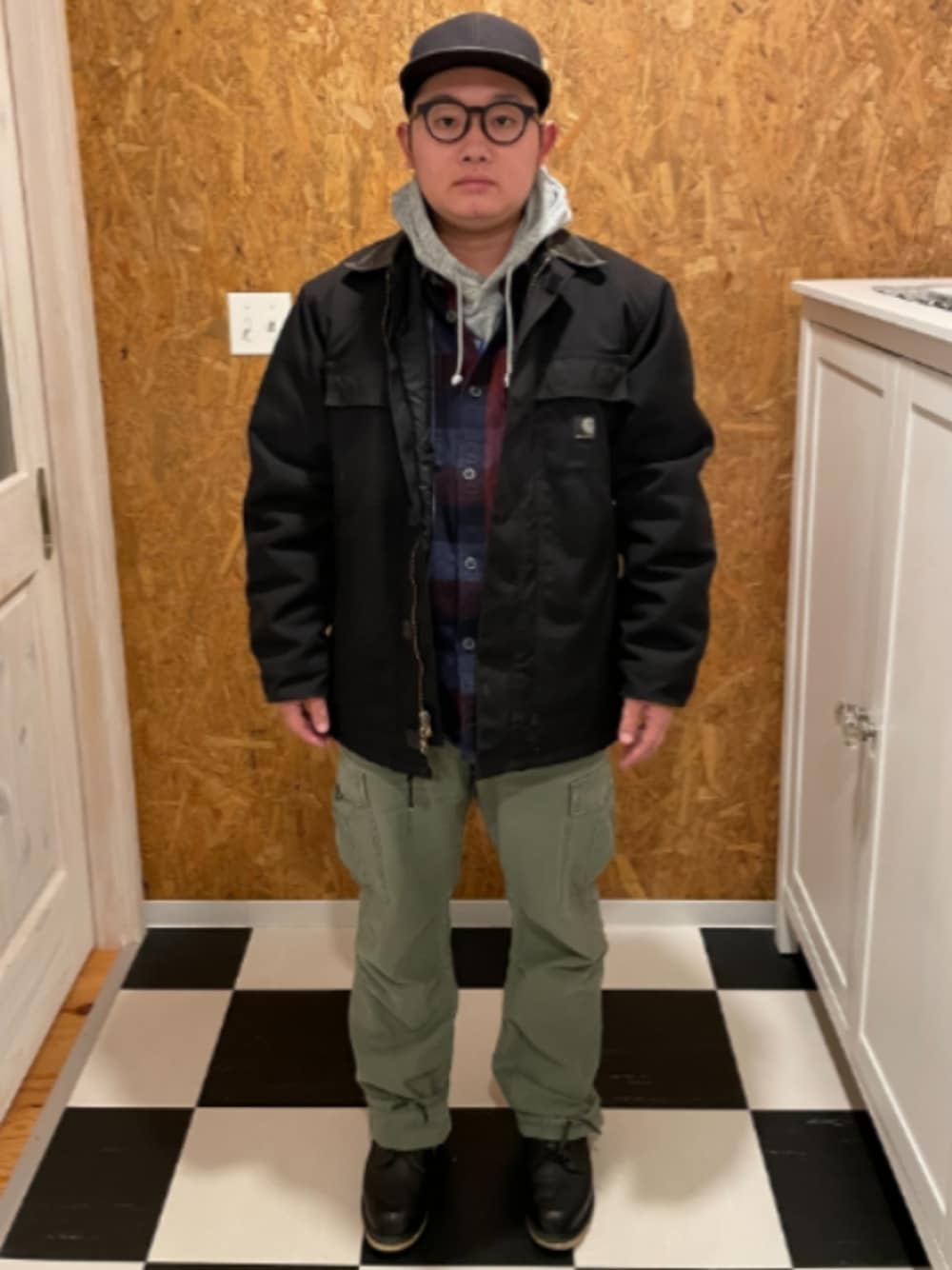 ブラック系のカバーオール、ブルー系のシャツ/ブラウス、グレー系のパーカーを着用したメンズの冬コーディネートの1枚目の写真