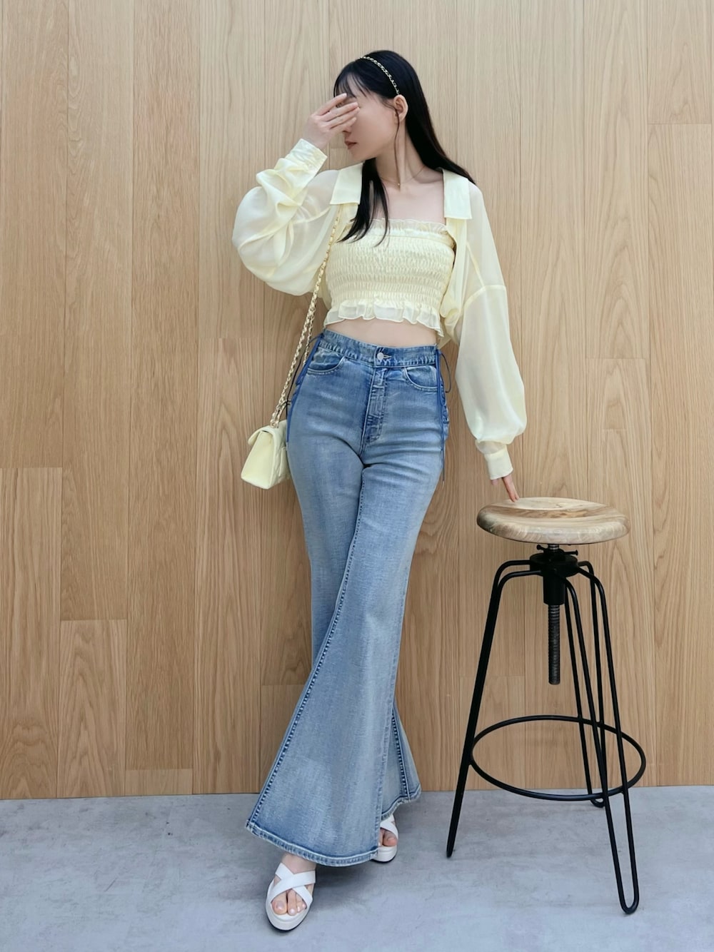 ホワイト系のサンダル、ブルー系のデニムパンツ、イエロー系のハンドバッグを着用したレディースの春コーディネートの1枚目の写真