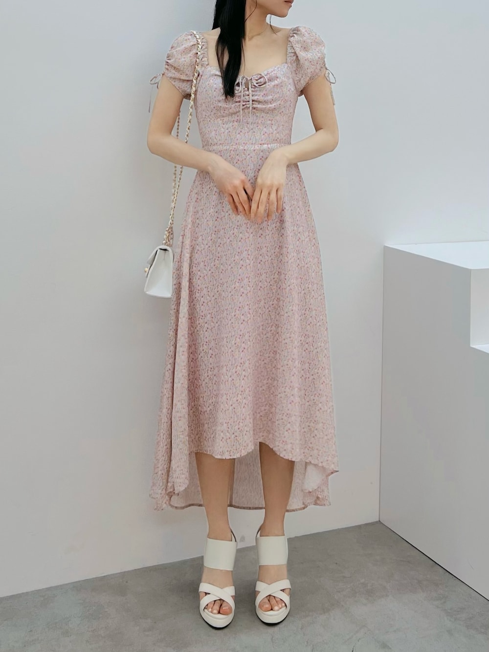 ピンク系のワンピース、ホワイト系のハンドバッグ、ホワイト系のサンダルを着用したレディースの春コーディネートの1枚目の写真