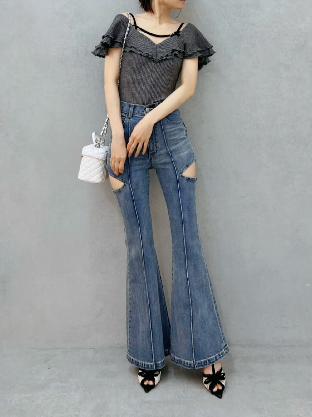 ブルー系のデニムパンツ、グレー系のTシャツ/カットソー、ホワイト系のハンドバッグを着用したレディースの夏コーディネートの1枚目の写真