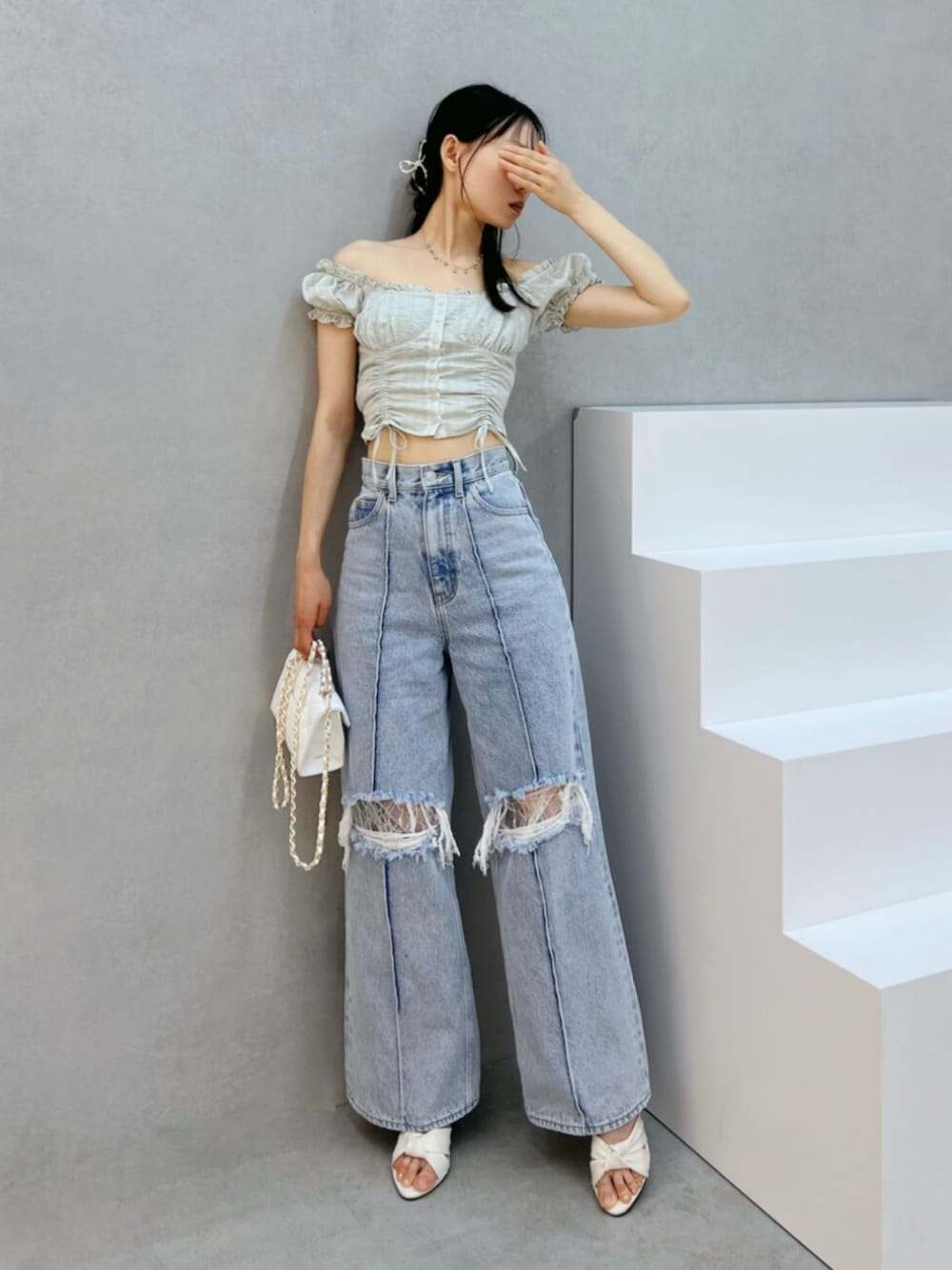 ホワイト系のハンドバッグ、ブルー系のデニムパンツ、グリーン系のシャツ/ブラウスを着用したレディースの夏コーディネートの1枚目の写真