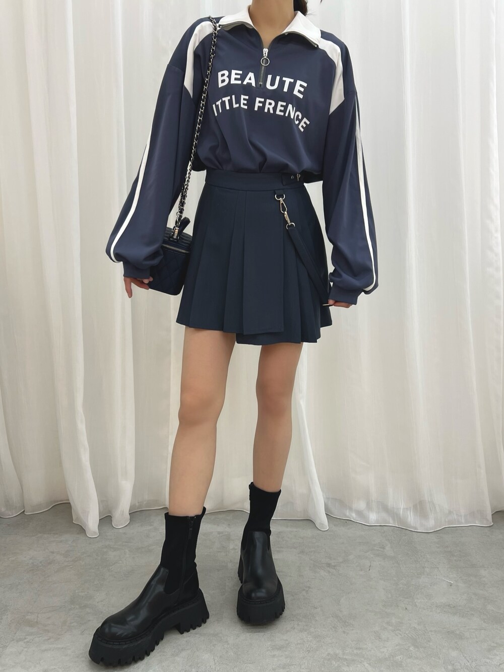 ブルー系のハンドバッグ、ブルー系のスカート、ブルー系のTシャツ/カットソーを着用したレディースの冬コーディネートの1枚目の写真