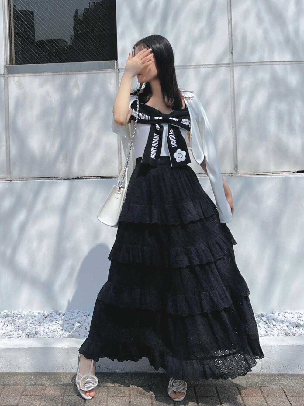 ブラック系のスカート、ホワイト系のワンピース、ホワイト系のサンダルを着用したレディースの春コーディネートの1枚目の写真