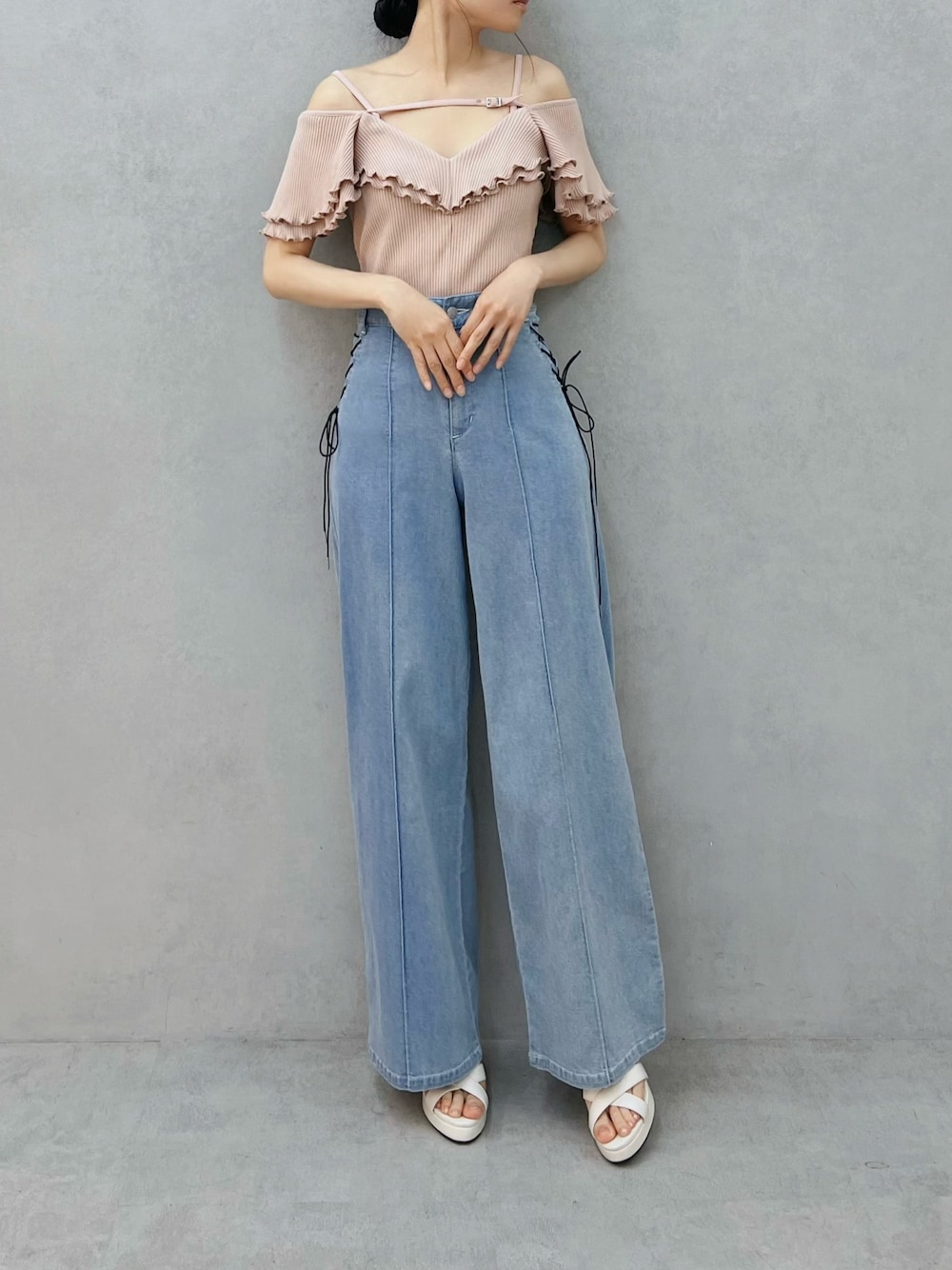 ブルー系のデニムパンツ、ピンク系のTシャツ/カットソー、ホワイト系のサンダルを着用したレディースの夏コーディネートの1枚目の写真
