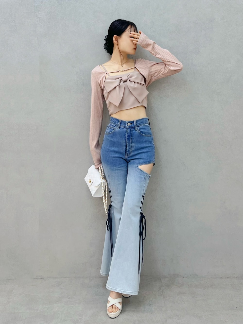 その他のデニムパンツ、ホワイト系のサンダル、ホワイト系のハンドバッグを着用したレディースの春コーディネートの1枚目の写真