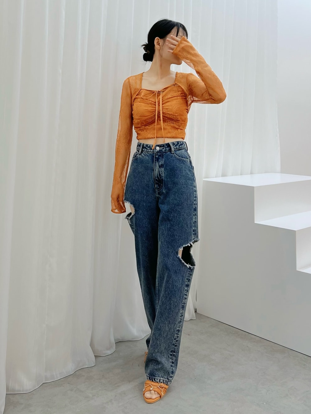 ブルー系のデニムパンツ、オレンジ系のシャツ/ブラウス、オレンジ系のサンダルを着用したレディースの秋コーディネートの1枚目の写真