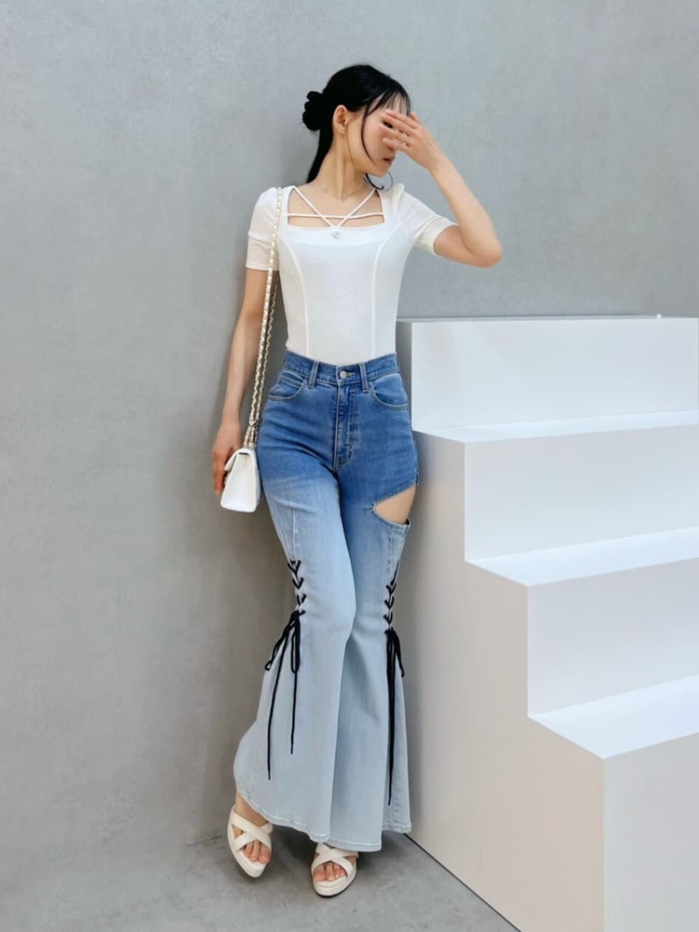 ホワイト系のハンドバッグ、ホワイト系のサンダル、その他のデニムパンツを着用したレディースの夏コーディネートの1枚目の写真