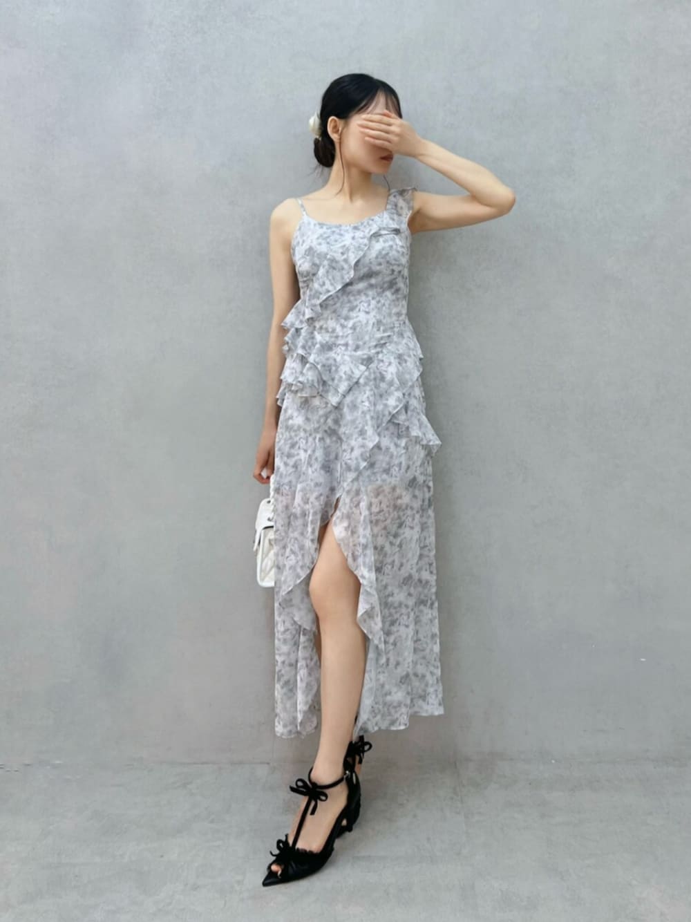 ホワイト系のハンドバッグ、グレー系のワンピース、ブラック系のパンプスを着用したレディースの夏コーディネートの1枚目の写真