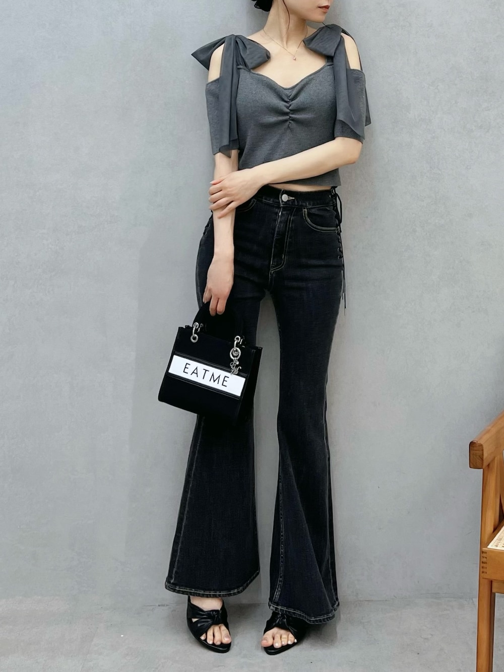 ブルー系のデニムパンツ、ブラック系のショルダーバッグ、グレー系のTシャツ/カットソーを着用したレディースの春コーディネートの1枚目の写真