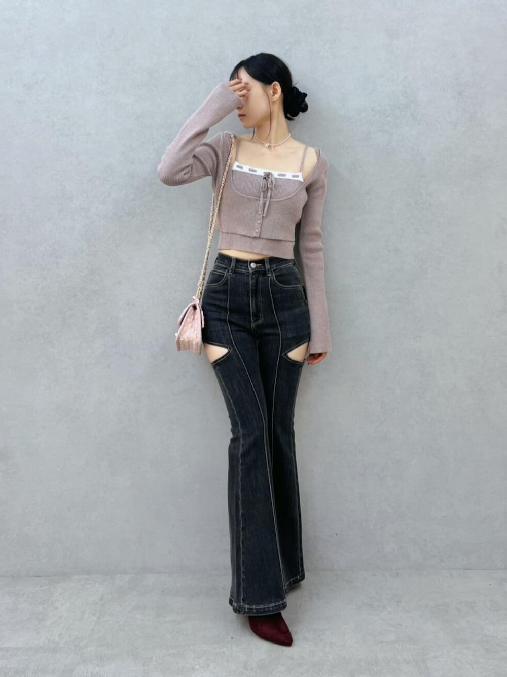 ブラック系のデニムパンツ、レッド系のブーツ、ベージュ系のニット/セーターを着用したレディースの夏コーディネートの1枚目の写真