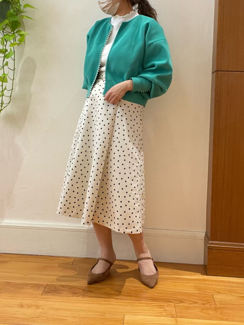 グリーン系のカーディガン/ボレロ、ホワイト系のスカート、ホワイト系のTシャツ/カットソーを着用したレディースの春コーディネートの1枚目の写真