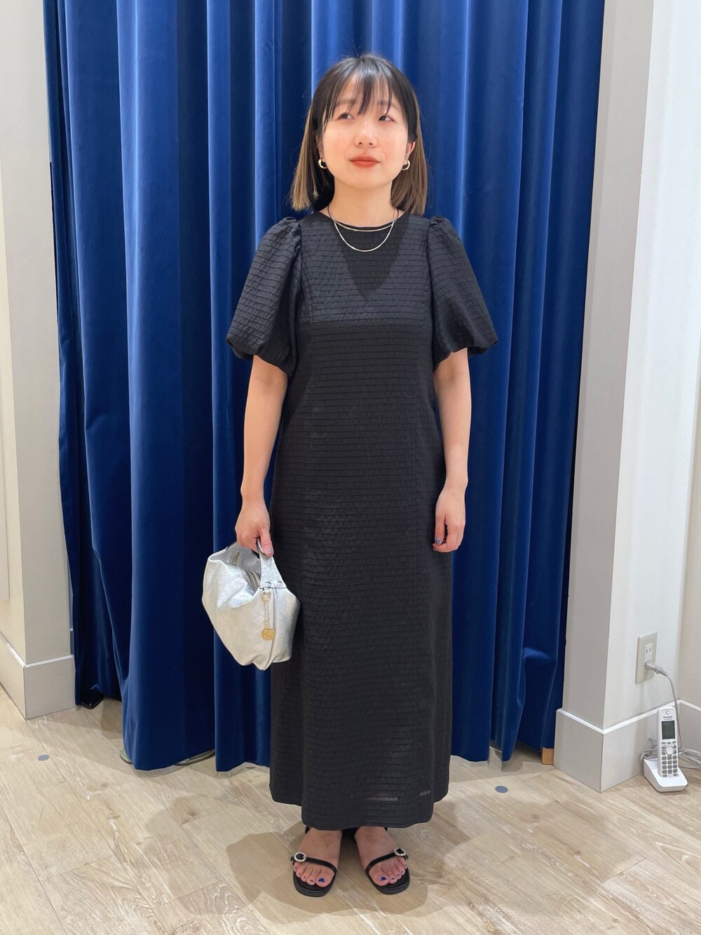 ブラック系のワンピースを着用したレディースの春コーディネートの1枚目の写真